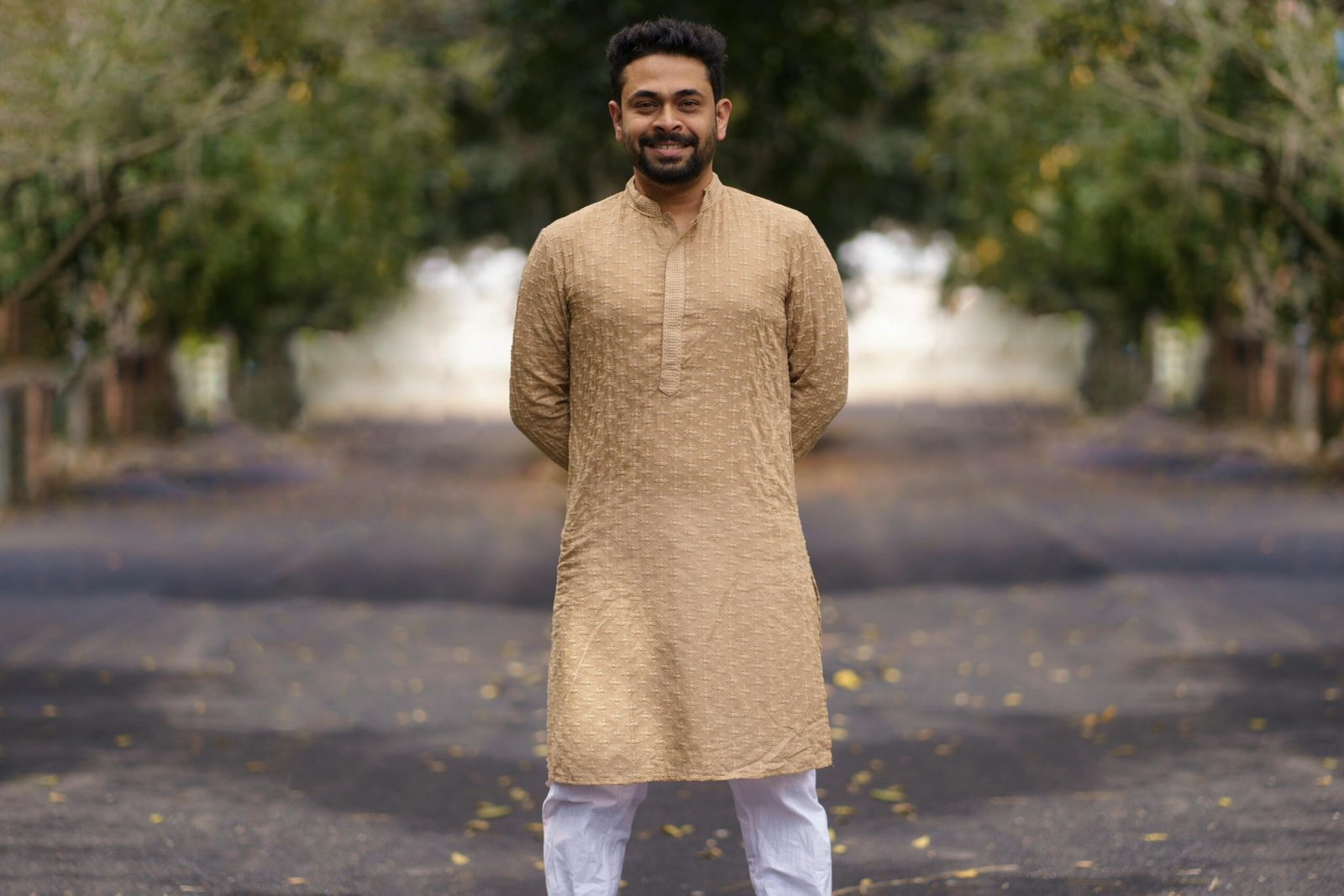 Portrait of a smiling man in a traditional kurta pyjama on a sunny day.